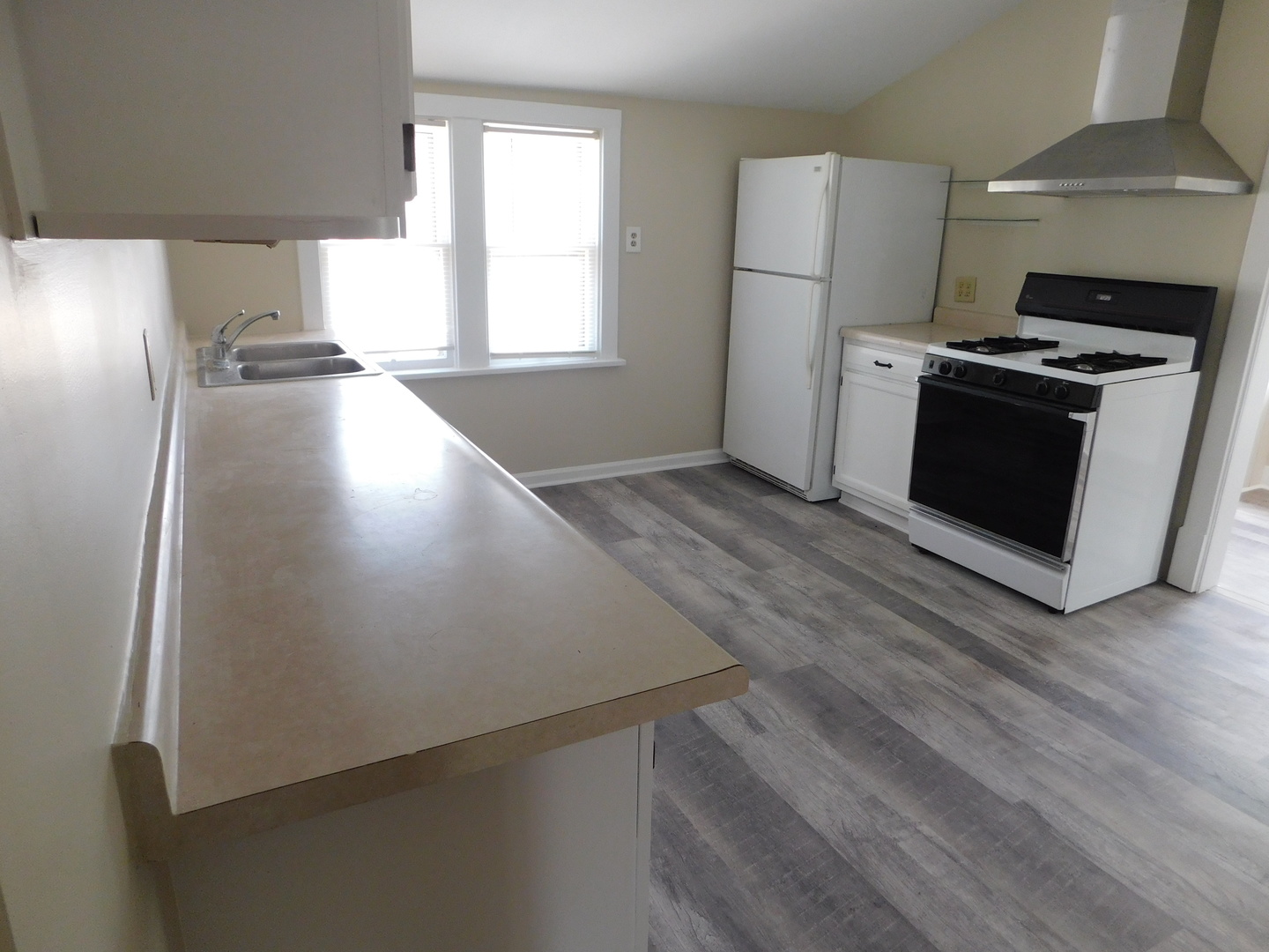 307 South Main Street Algonquin, IL 60102 - Photo 4 of 15 an empty room with wooden floor and a kitchen view