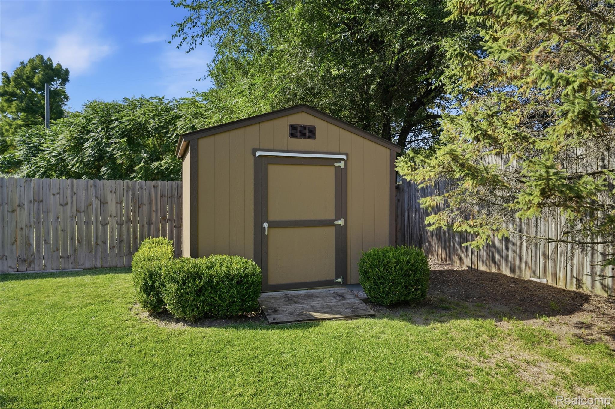 1087 Collingwood Drive Rochester, MI 48307 - Photo 8 of 56 Storage shed with a single door, surrounded by manicured shrubs