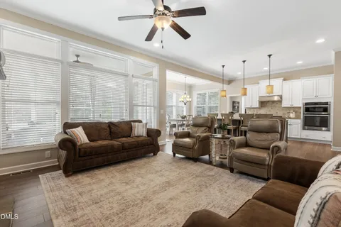 a kitchen with a refrigerator a stove a sink and white cabinets with wooden floor