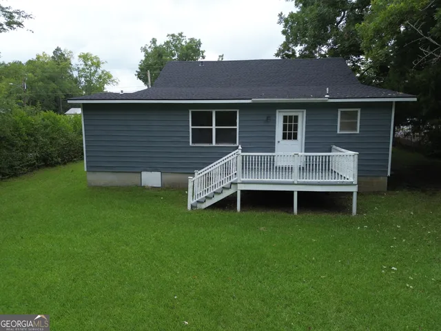 a view of a house with a backyard and a patio