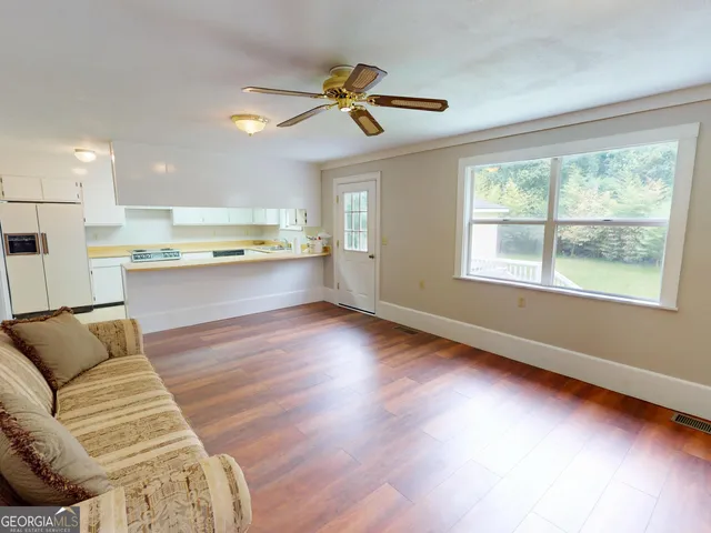 a living room with stainless steel appliances furniture and a large window