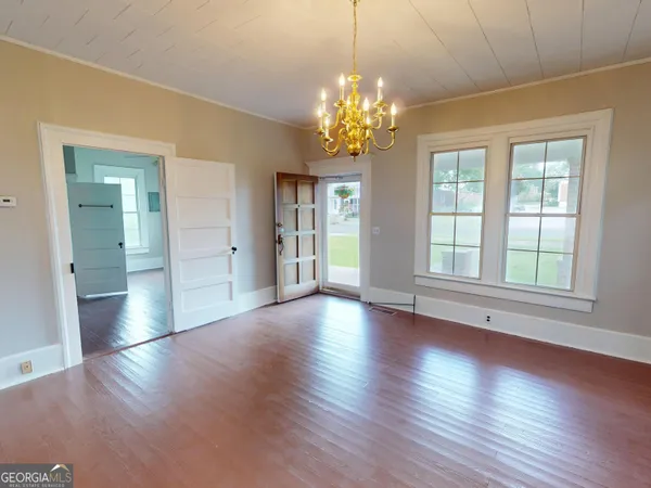a view of a big room with wooden floor and a chandelier