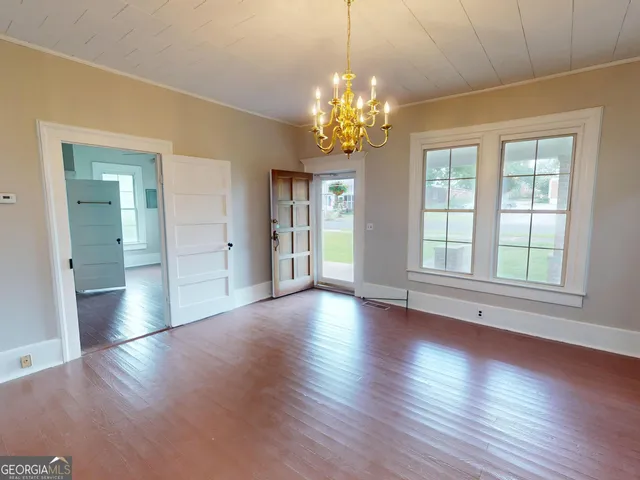 a view of a big room with wooden floor and a chandelier