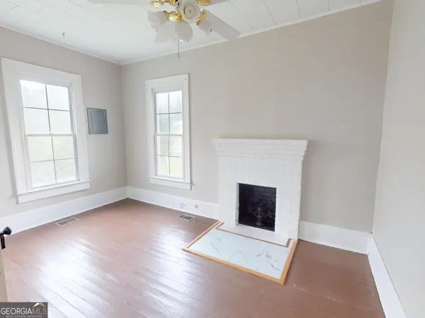 an empty room with windows and fireplace