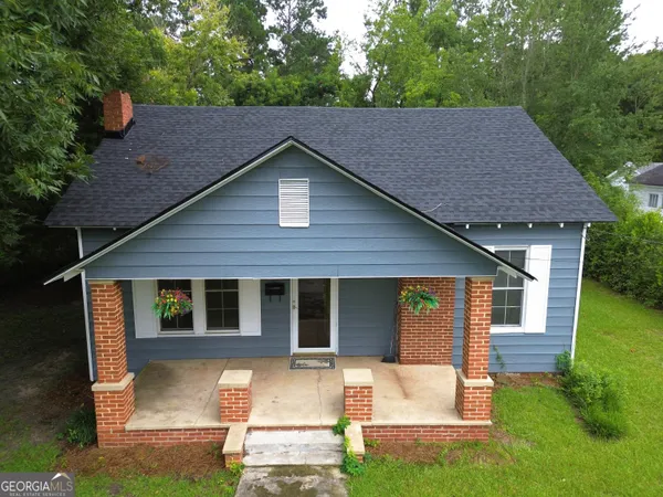 a view of house with yard and outdoor seating