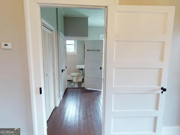 a view of a hallway with wooden floor and a closet