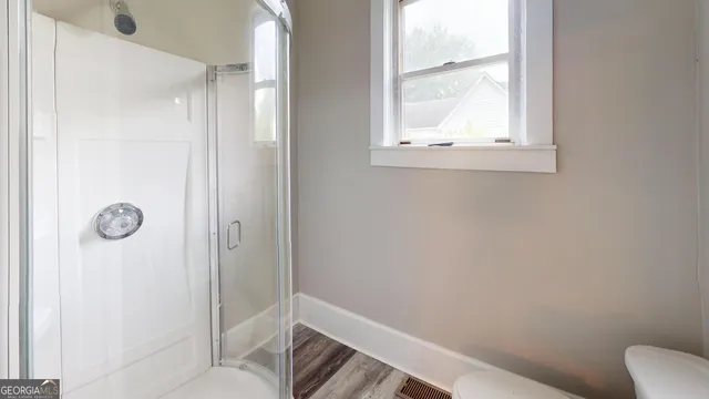 a bathroom with a window and a shower