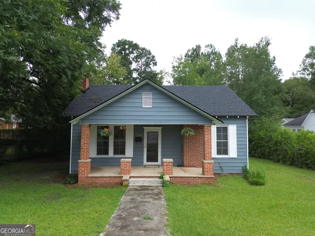 a view of a house with a yard and sitting area
