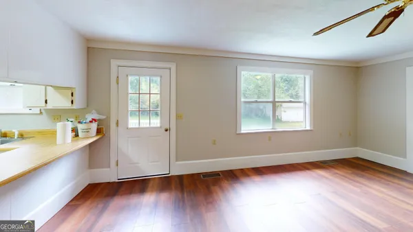 an empty room with windows and fireplace