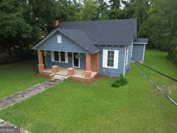 a front view of a house with yard and green space