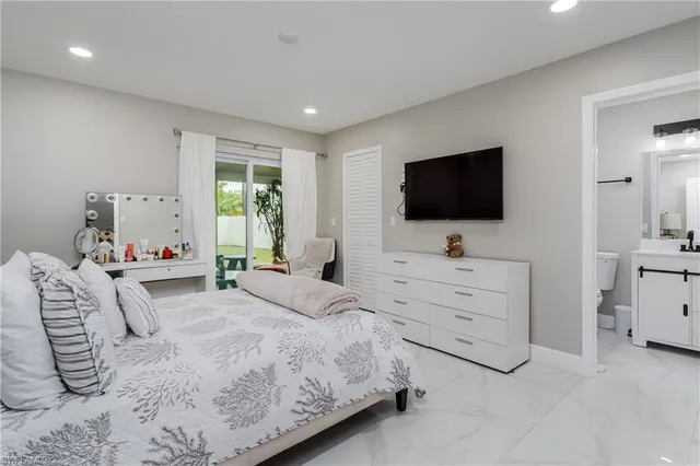 a bedroom with a bed and a flat screen tv