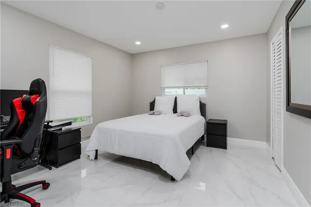 a bedroom with a bed and a flat tv screen on the dresser