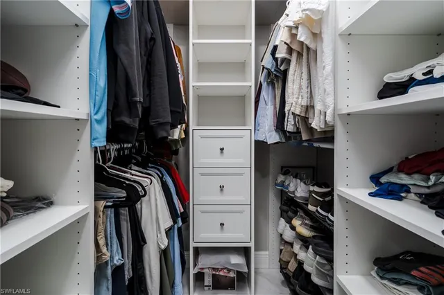 a view of walk in closet with clothes and shoes