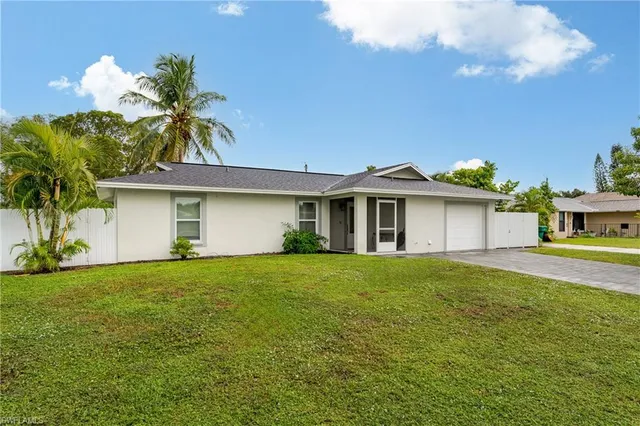 a front view of a house with a garden and yard