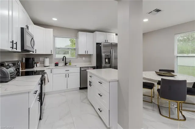 a kitchen with cabinets and chairs