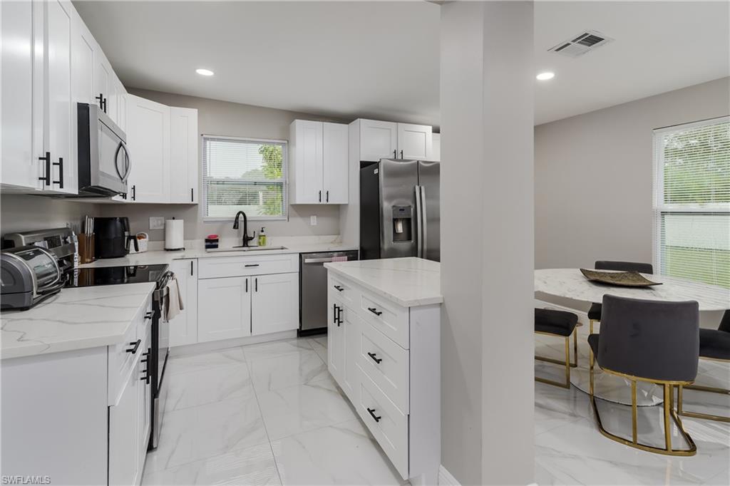 5170 19th Court Southwest Naples, FL 34116 - Photo 6 of 32 a kitchen with cabinets and chairs