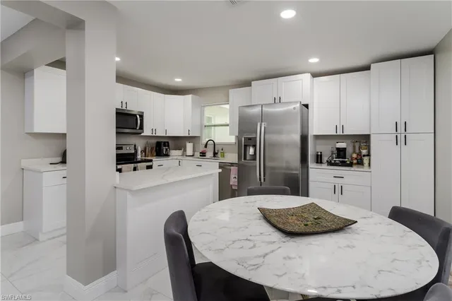 a kitchen with refrigerator and white cabinets