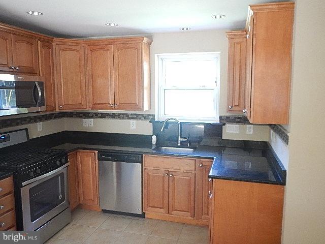 4406 Mahan Road Silver Spring, MD 20906 - Photo 4 of 12 a kitchen with stainless steel appliances granite countertop a stove a sink and a microwave