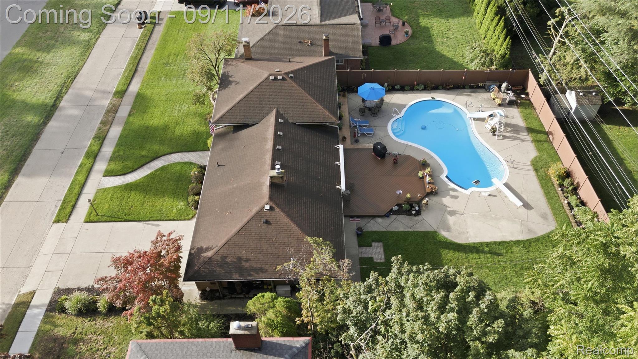 16799 Farmington Road Livonia, MI 48154 - Photo 60 of 71 Fenced backyard featuring a large in-ground swimming pool, concrete pool deck, and a wood-finish deck