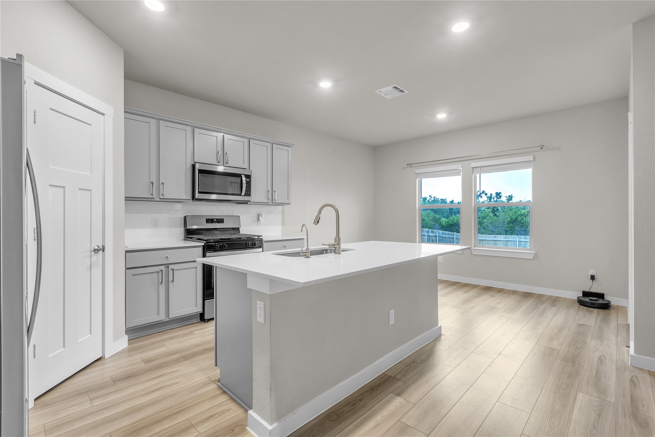 1212 Tipton Street Georgetown, TX 78633 - Photo 5 of 20 Modern kitchen with an island breakfast bar, stainless steel appliances, and a seamless open-concept design.