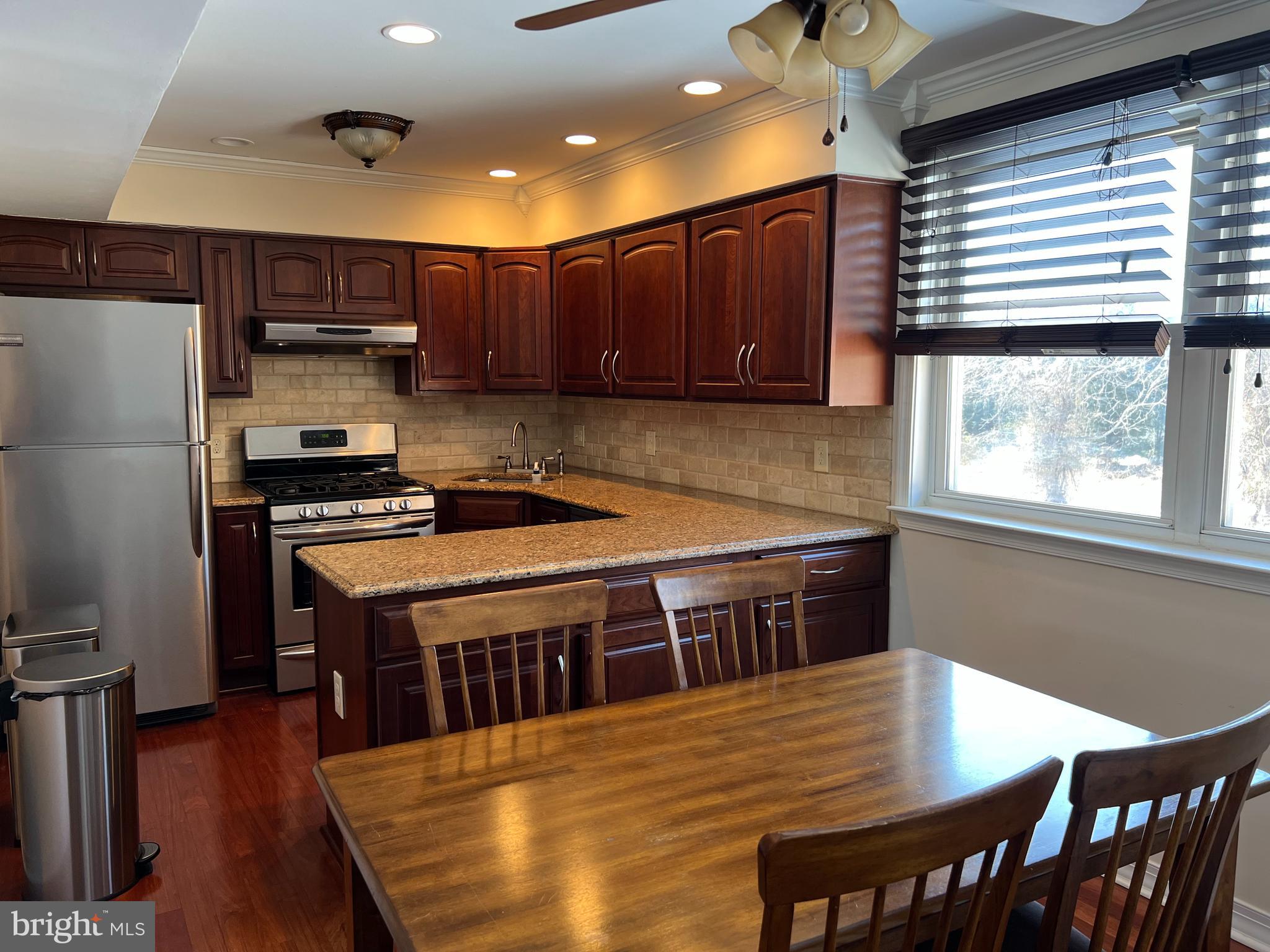 100 Eaves Mill Road Medford, NJ 08055 - Photo 2 of 16 a kitchen with stainless steel appliances wooden cabinets a stove a sink and a refrigerator