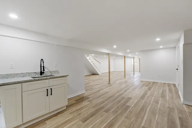 a hallway with wooden floor closet and windows