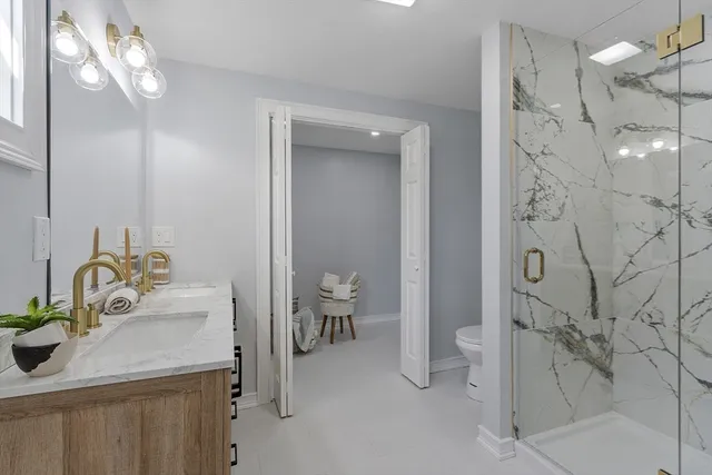 a bathroom with a sink a toilet and shower