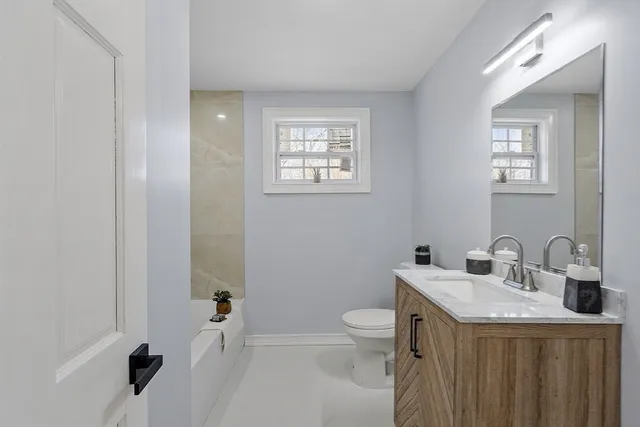 a bathroom with a toilet sink and mirror