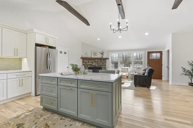 a kitchen with kitchen island granite countertop a stove top oven a sink a dining table and chairs