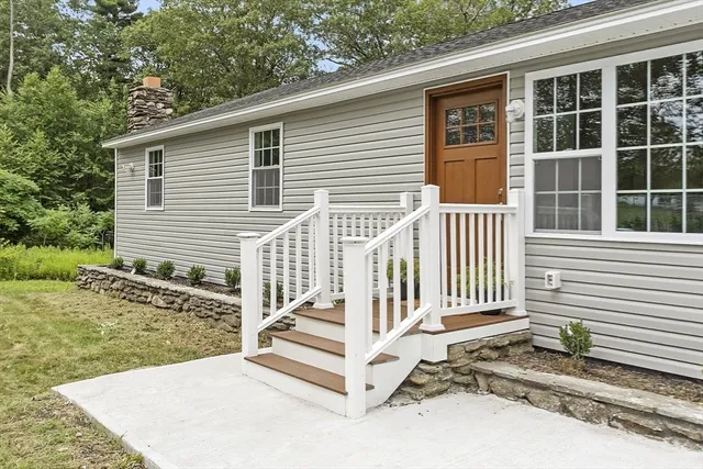 a view of a house with a yard and floor to ceiling window and wooden fence
