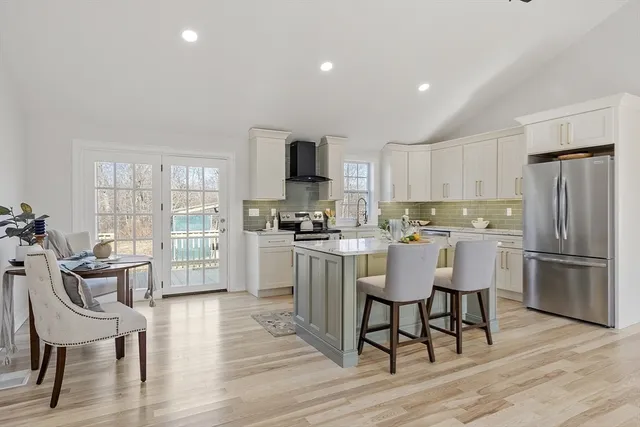 a kitchen with a dining table chairs refrigerator and cabinets