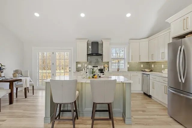 a kitchen with refrigerator and chairs