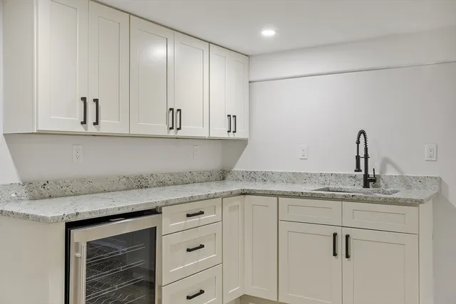 a kitchen with granite countertop white cabinets and white appliances