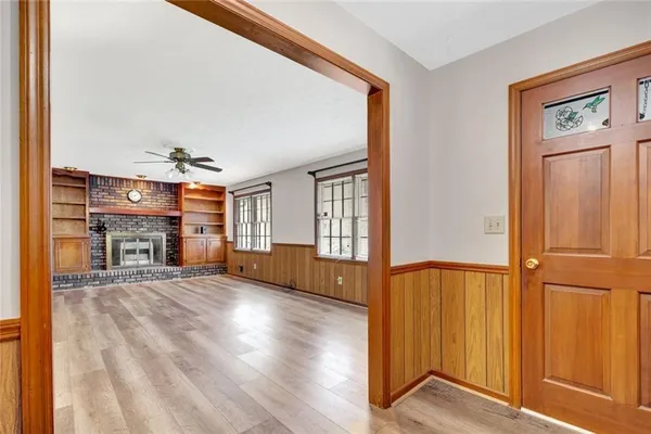 a view of an empty room with wooden floor and a window