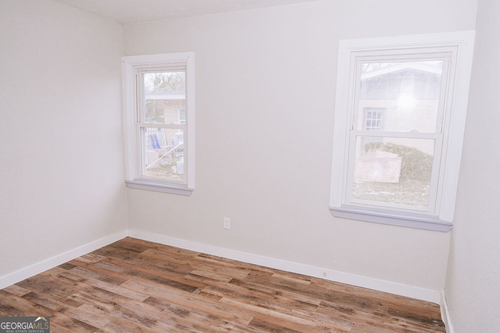 3017 Albany Avenue Waycross, GA 31503 - Photo 9 of 23 an empty room with wooden floor and windows