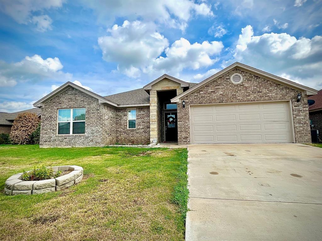 a front view of a house with a garden and yard