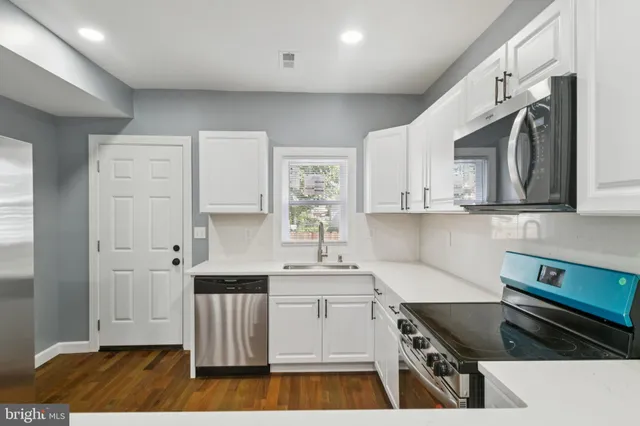 a kitchen with granite countertop a stove and cabinets