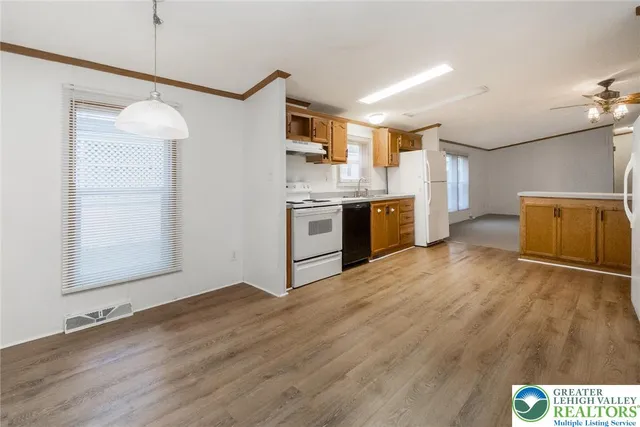 a open kitchen with a refrigerator and a stove top oven
