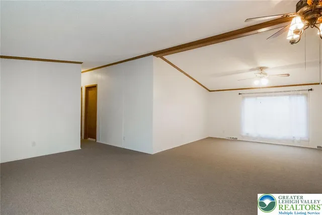an empty room with a ceiling fan and a window