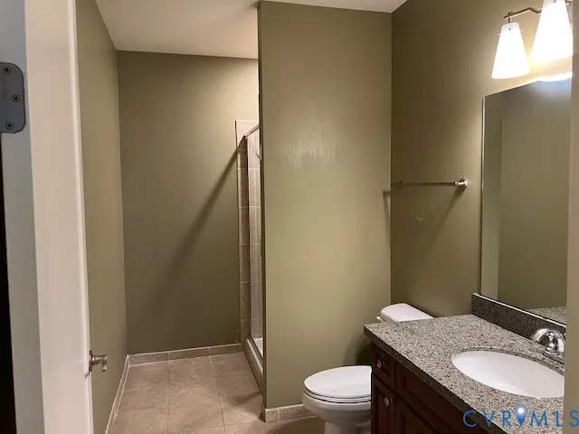 a bathroom with a granite countertop toilet sink and mirror