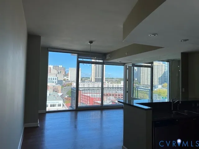 a living room with hardwood floor and large window
