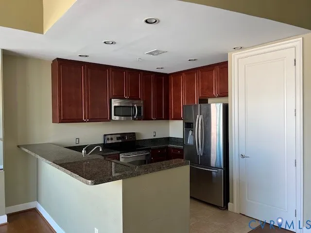 a kitchen with a refrigerator sink and cabinets