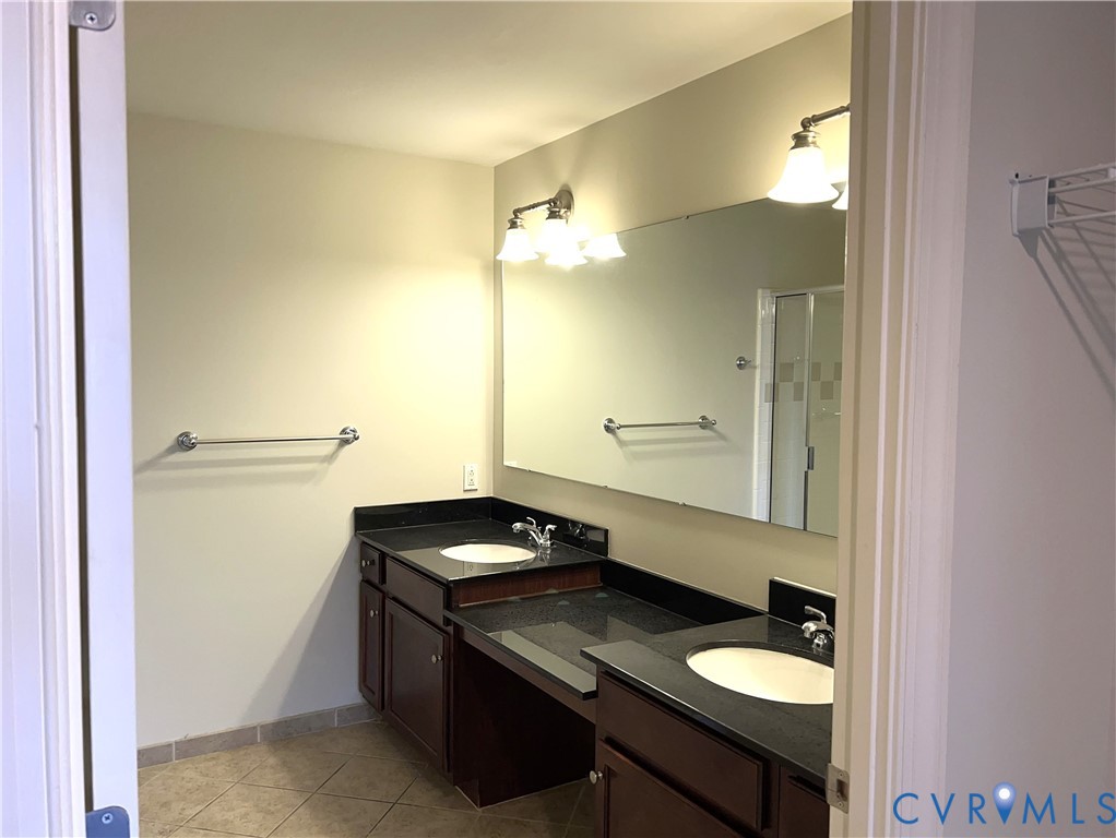 301 Virginia Street, Unit 1102 Richmond, VA 23219 - Photo 10 of 28 a bathroom with a granite countertop sink a toilet and a mirror