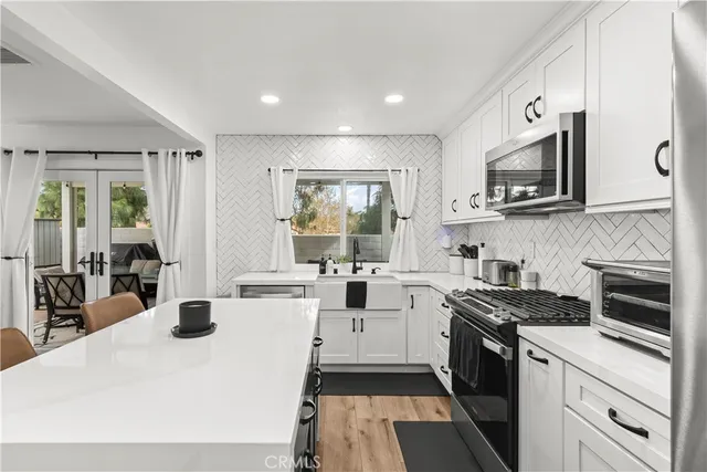 a kitchen with stainless steel appliances granite countertop a refrigerator sink and stove