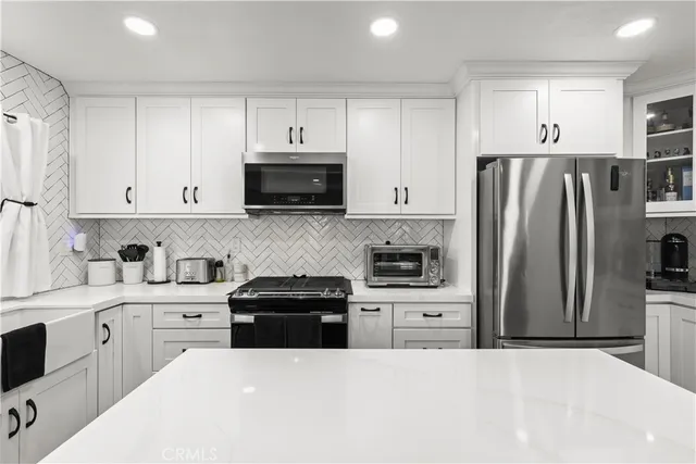 a kitchen with stainless steel appliances a stove sink microwave and cabinets