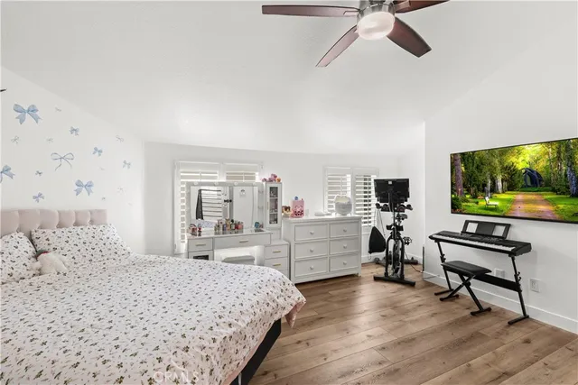 a bedroom with a bed and a bookshelf with wooden floor