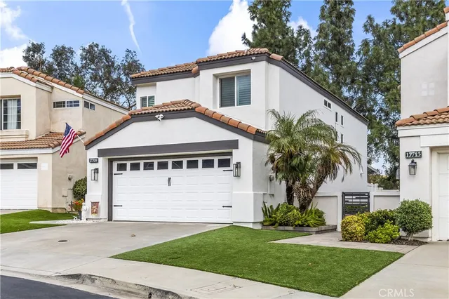 a front view of a house with a garden and trees