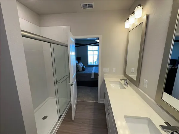 a walk in closet with view of bathroom