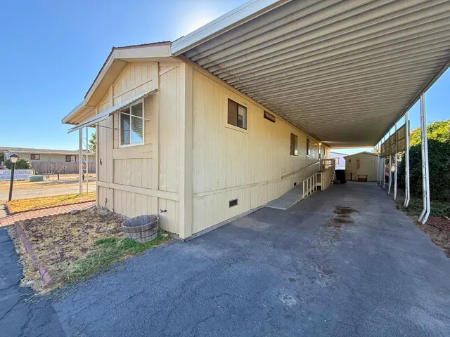 a view of a house with backyard and utility area