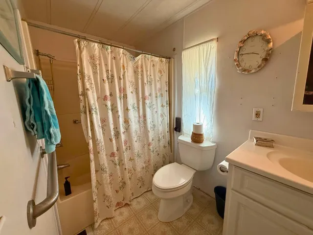 a bathroom with a toilet a sink and curtain